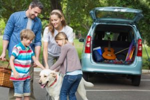 Family on summer trip with their dog